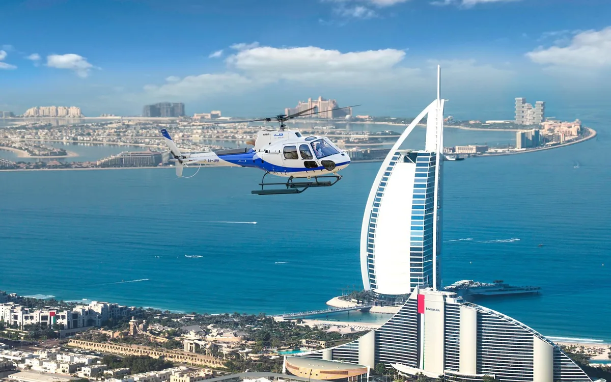 A helicopter over the Burj Al Arab and the Dubai coast