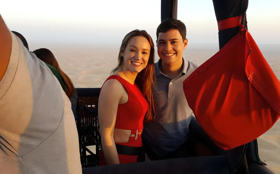 Passengers in a hot air balloon basket over the Dubai desert